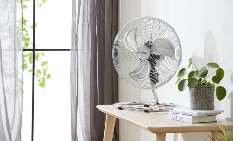 A Dimplex fan sits on a desk in a bright and airy room.