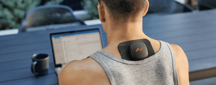 a man wearing the hyperice venom go massager whilst doing work